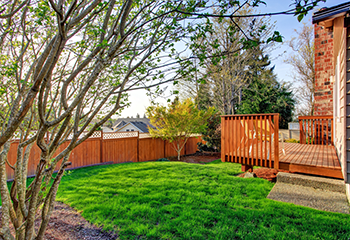 The image shows a newly installed wooden deck in a backyard patio.